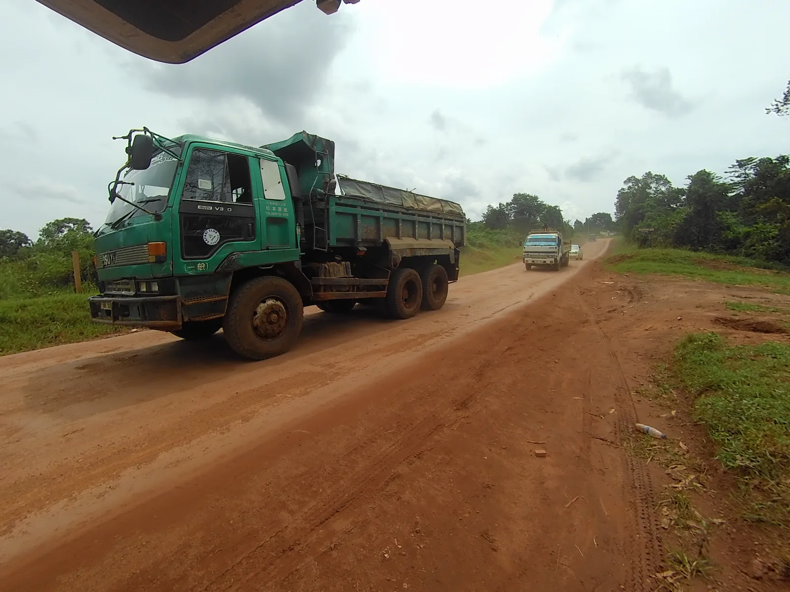A truck on a red dirt road. — Photo: Elisha Muwanguzi / Wikimedia Commons (CC BY-SA 4.0)
