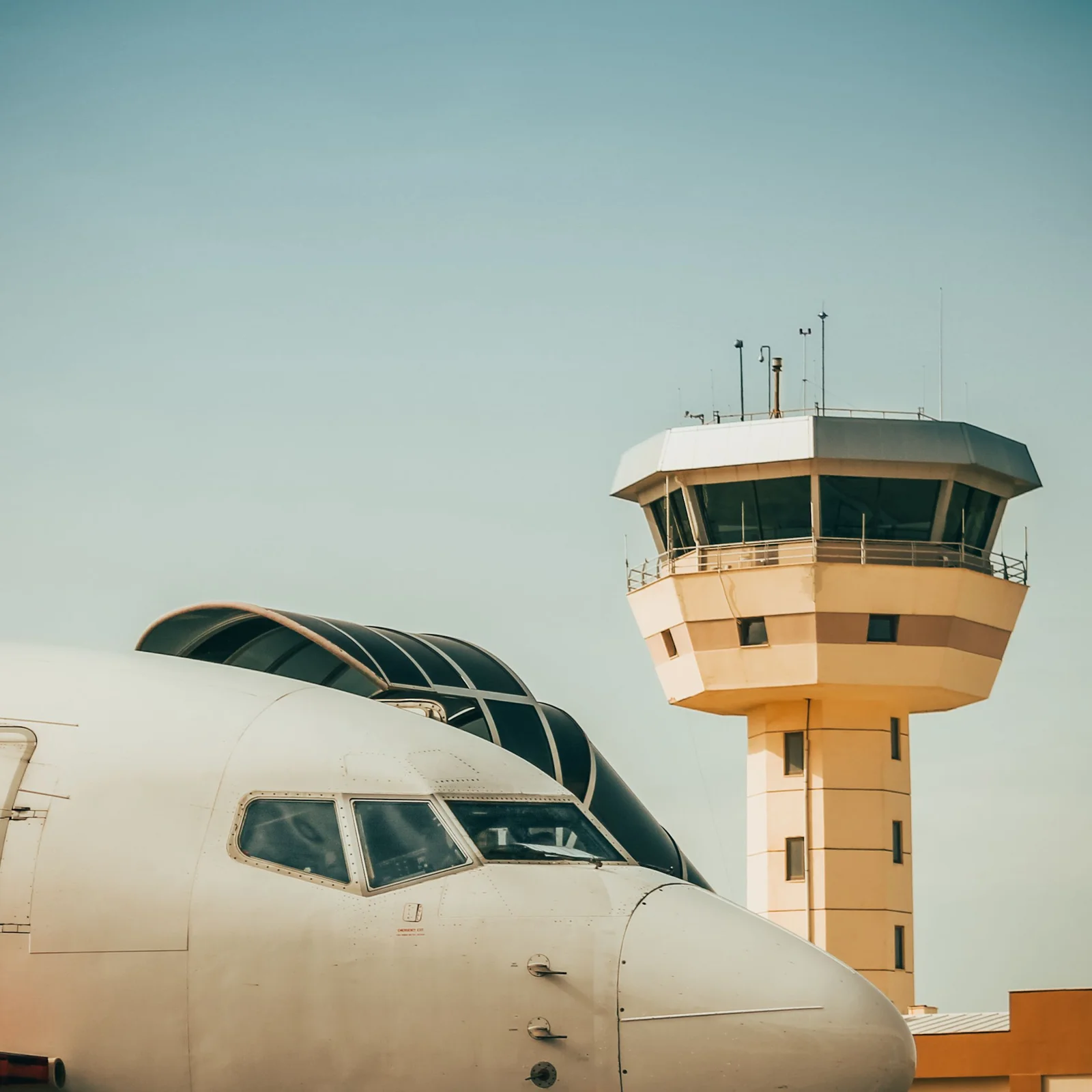 The nose of a commercial airliner with an airport control tower behind it. File photo — it does not depict Alula Aba Nega Airport or the events described in this article.