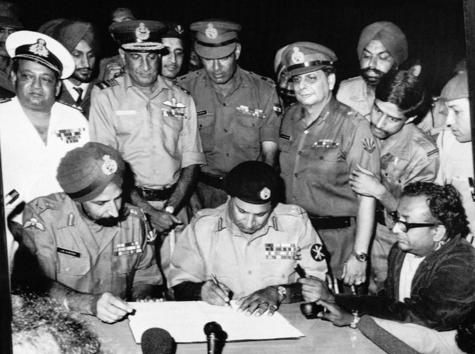 Lt Gen A. A. K. Niazi signing the Instrument of Surrender in Dhaka on 16 December 1971, with Lt Gen Jagjit Singh Aurora, commander of the joint Indian and Bangladesh forces in the east, seated beside him (contemporary photograph).