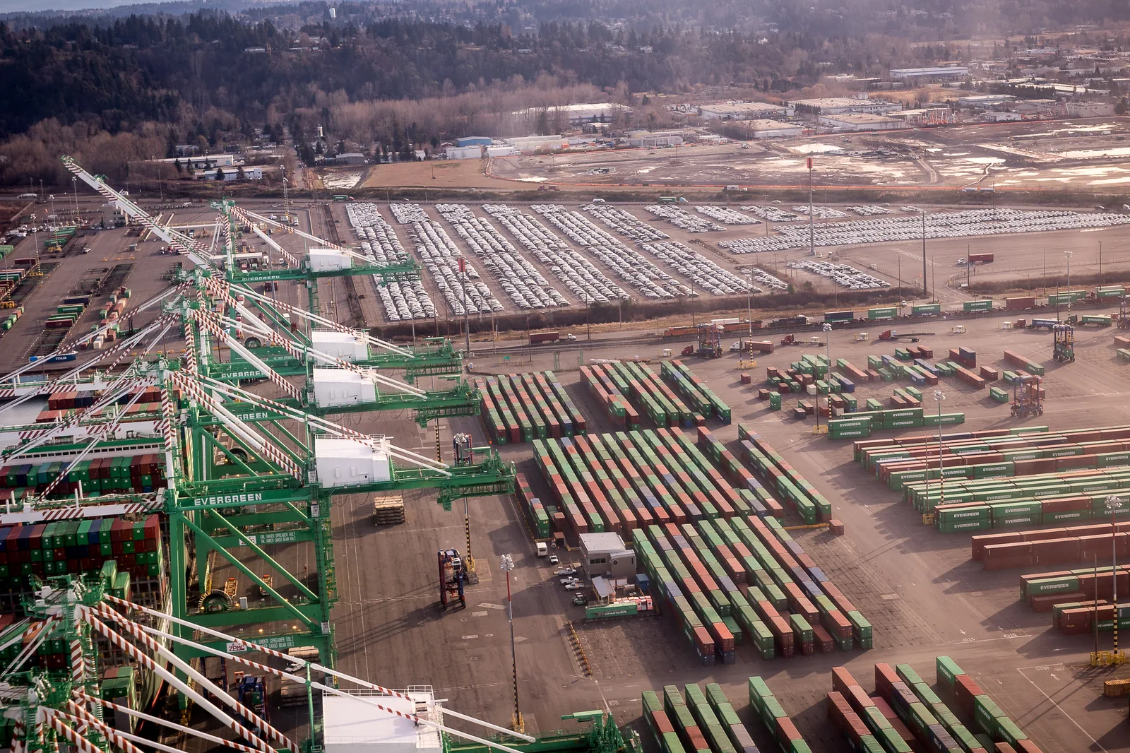 Container cranes and stacked containers at a port, seen from above. — Photo: Brian Harris / Wikimedia Commons (Public domain)