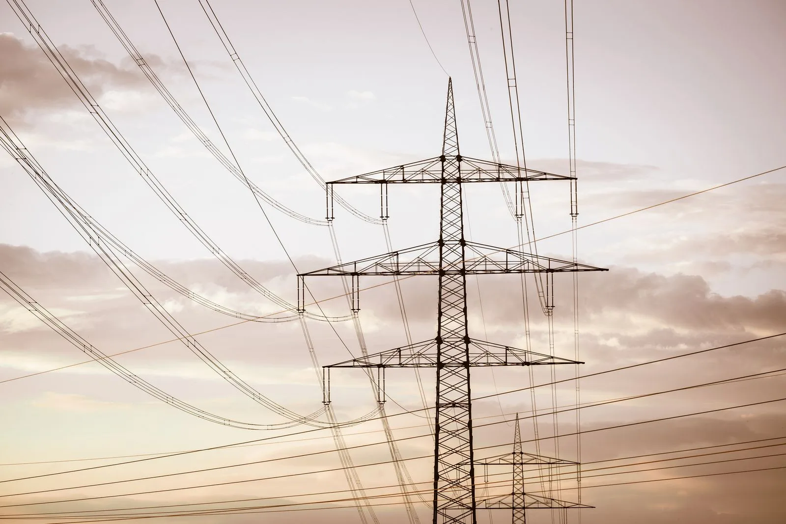 An electricity transmission pylon and high-voltage lines at dusk (generic file photo). Energy ceasefires turn on whether grids and power plants are inside the agreed scope.