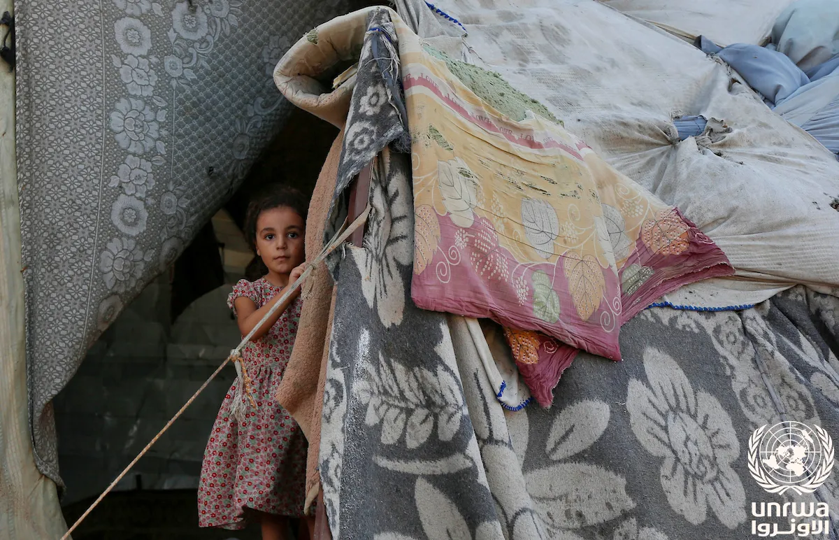 A displaced girl stands at the entrance of her family's tent in Deir el-Balah, central Gaza (file photo). Children make up nearly half of Gaza's population and, on the figures documented in this article, more than a quarter of its dead. This photo does not depict any individual named in the article.