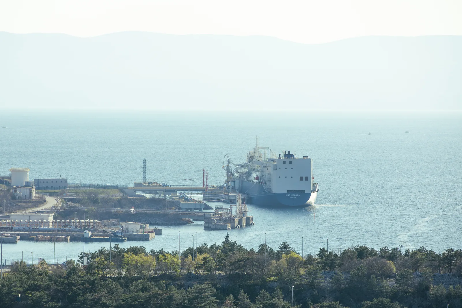 An oil and gas tanker at a coastal loading terminal (file photo). Iran's IRGC Navy said seven vessels were hit in the Persian Gulf and near the Strait of Hormuz; the claim had no independent confirmation in the reporting opened for this article. This photo does not depict any vessel or event reported here.