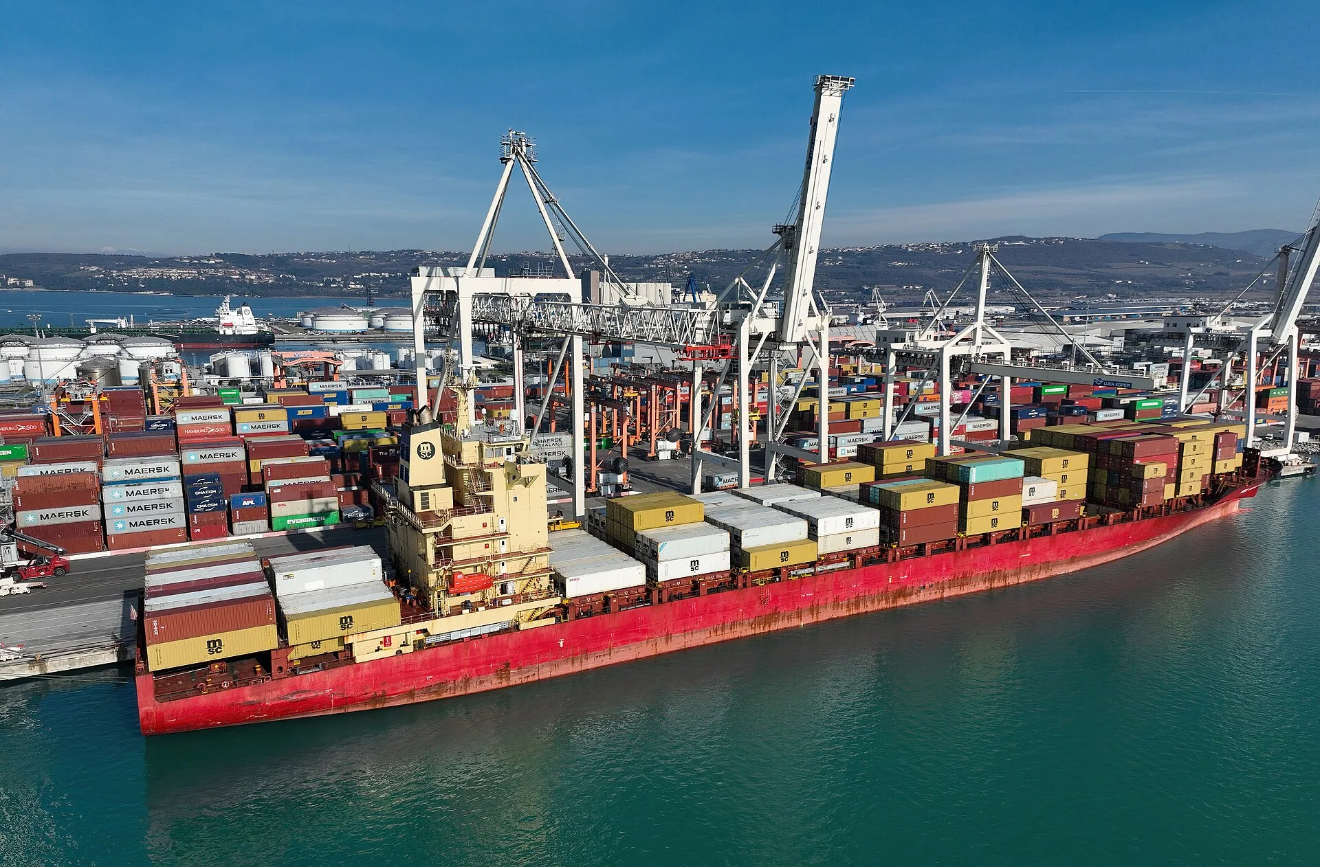 A container ship loading at port (file photo). This photo does not depict either vessel or any event reported in this article.