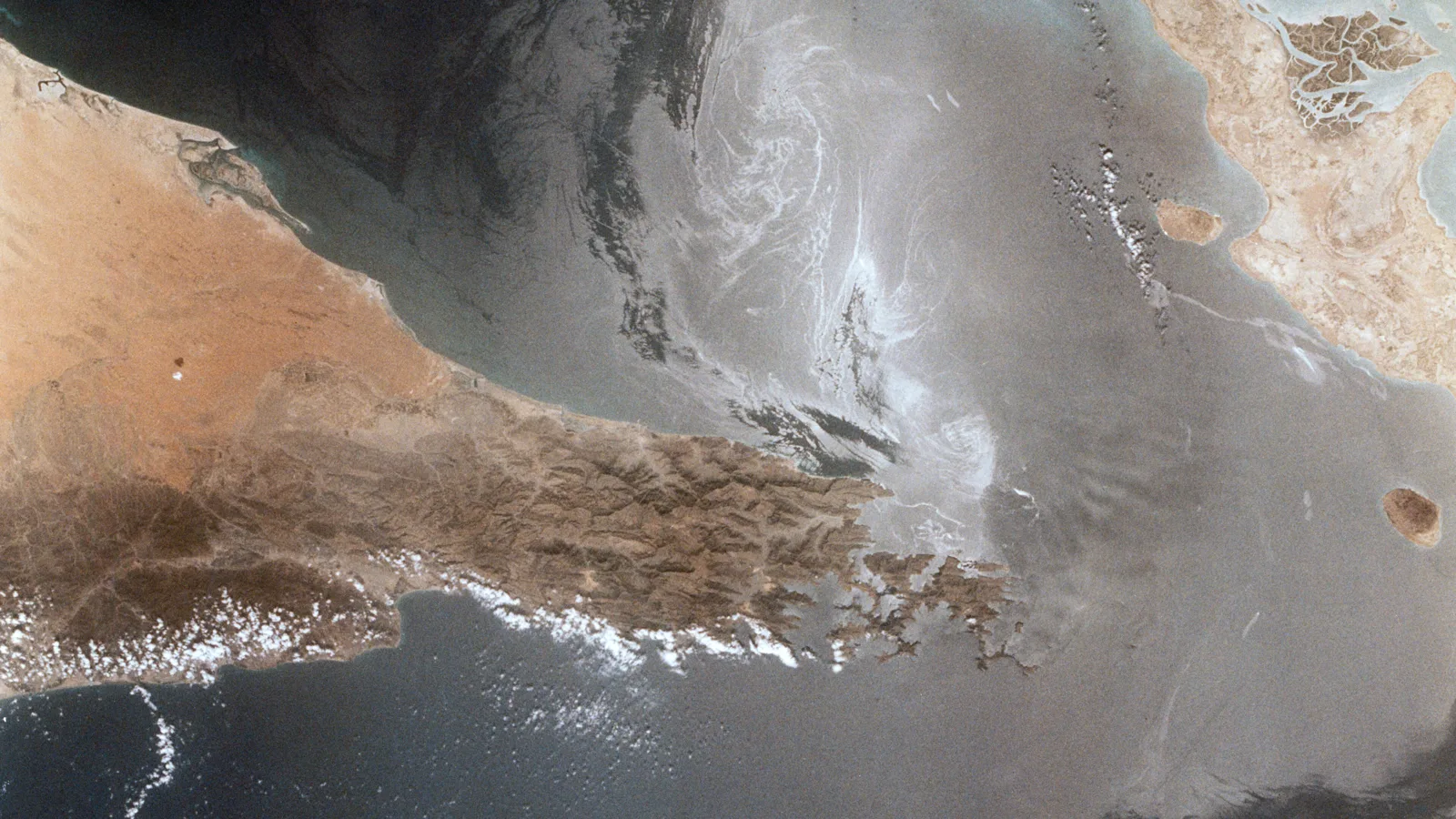 The Strait of Hormuz photographed from orbit (NASA file photo). This photo does not depict any vessel or event reported in this article.