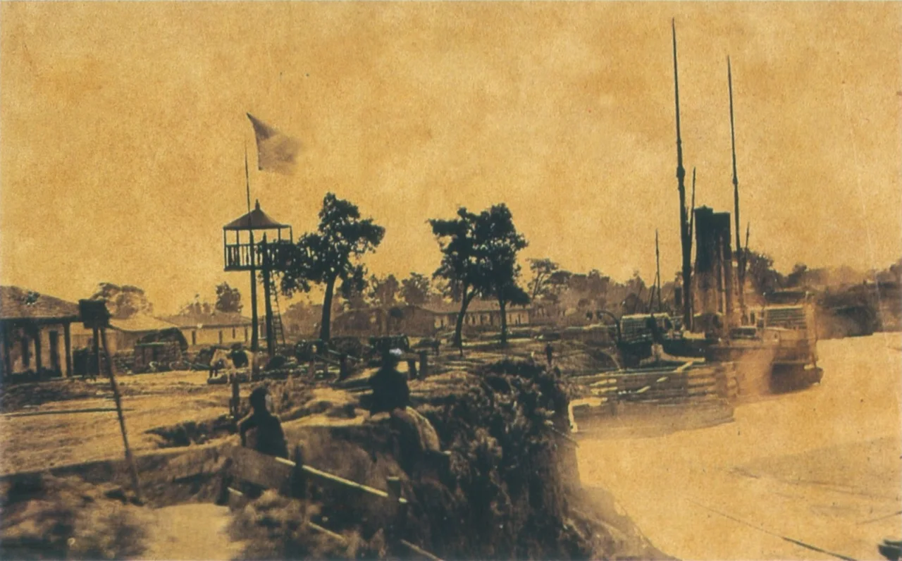 The port of the Humaitá fortress on the Paraguay River in an albumen photograph of 1868, after allied forces captured the position — the imperial Brazilian flag flies over the landing. Period photograph of the place, not a depiction of fighting.