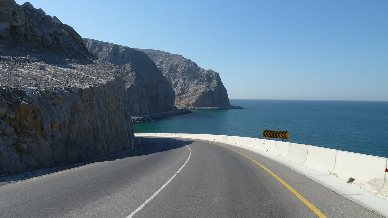 The coastal road along the cliffs of Oman's Musandam Peninsula near Khasab, on the southern shore of the Strait of Hormuz (file photo). UKMTO put Thursday night's attack 25 nautical miles northeast of Khasab. This photo does not depict any event reported in this article.