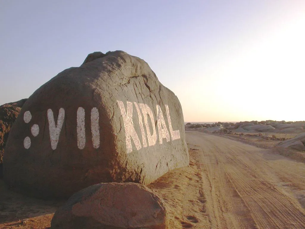 The entry sign of Kidal, northern Mali, with the town's name written in Tifinagh script. File photo — it does not depict the October 2026 military operations around the town.