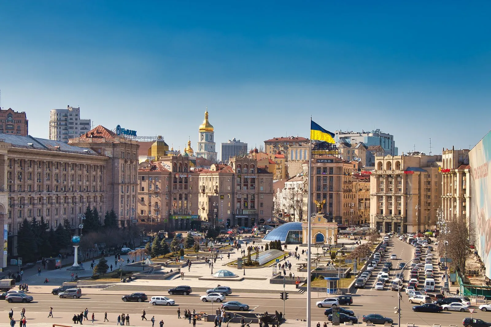 Maidan Nezalezhnosti (Independence Square) in Kyiv, with the Ukrainian flag flying.