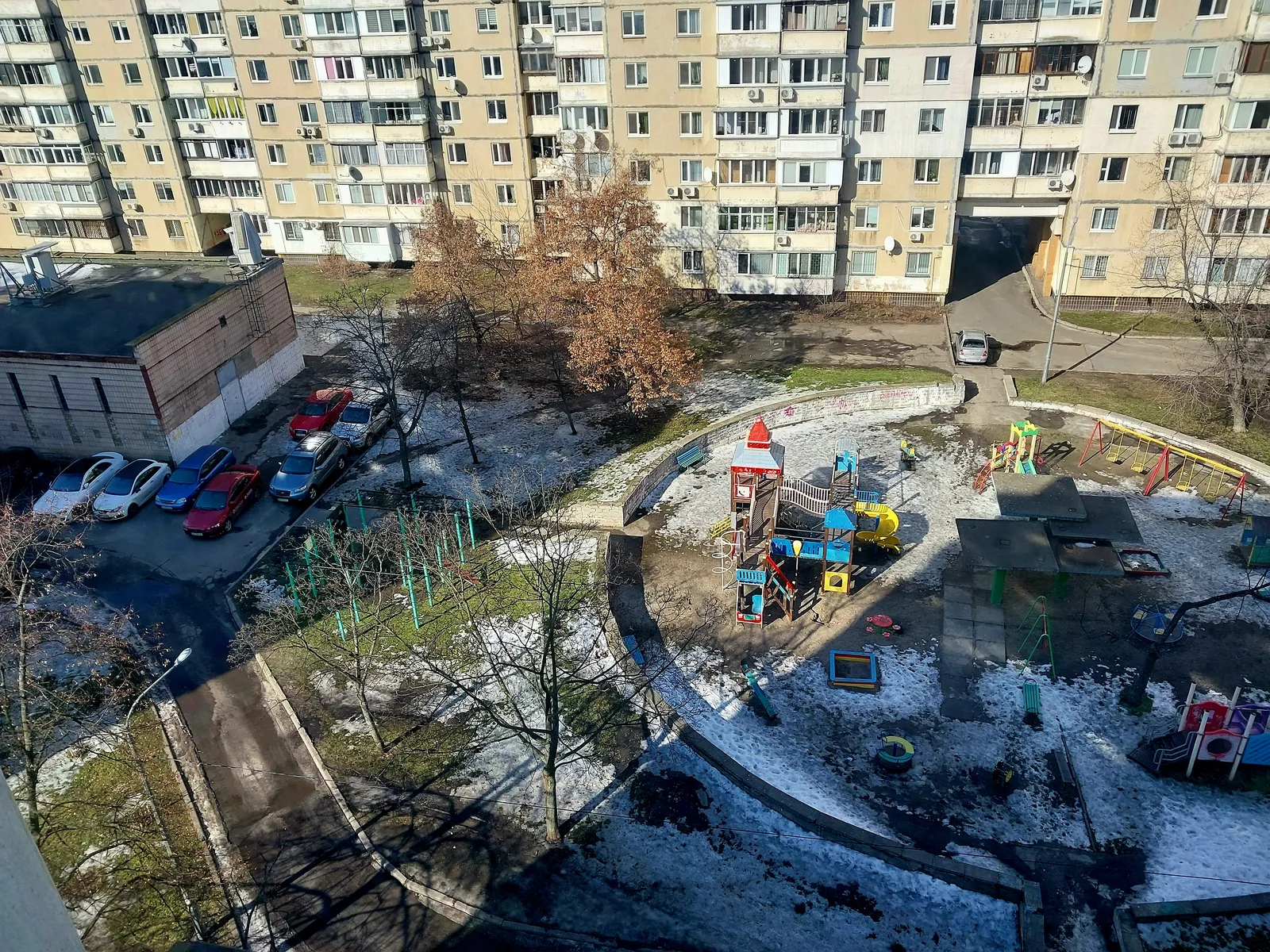 A residential courtyard in Kyiv with patches of melting snow around apartment blocks and a children's playground (file photo). This photo does not depict any event reported in this article.