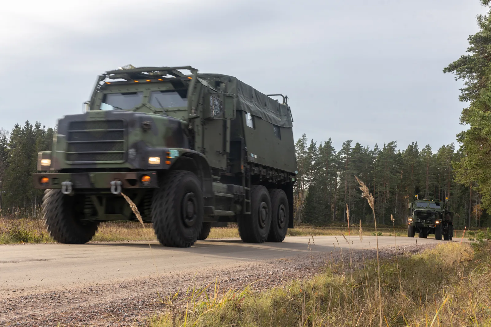 Military trucks in convoy on a forest road. — Photo: U.S. Marine Corps / Wikimedia Commons (Public domain)