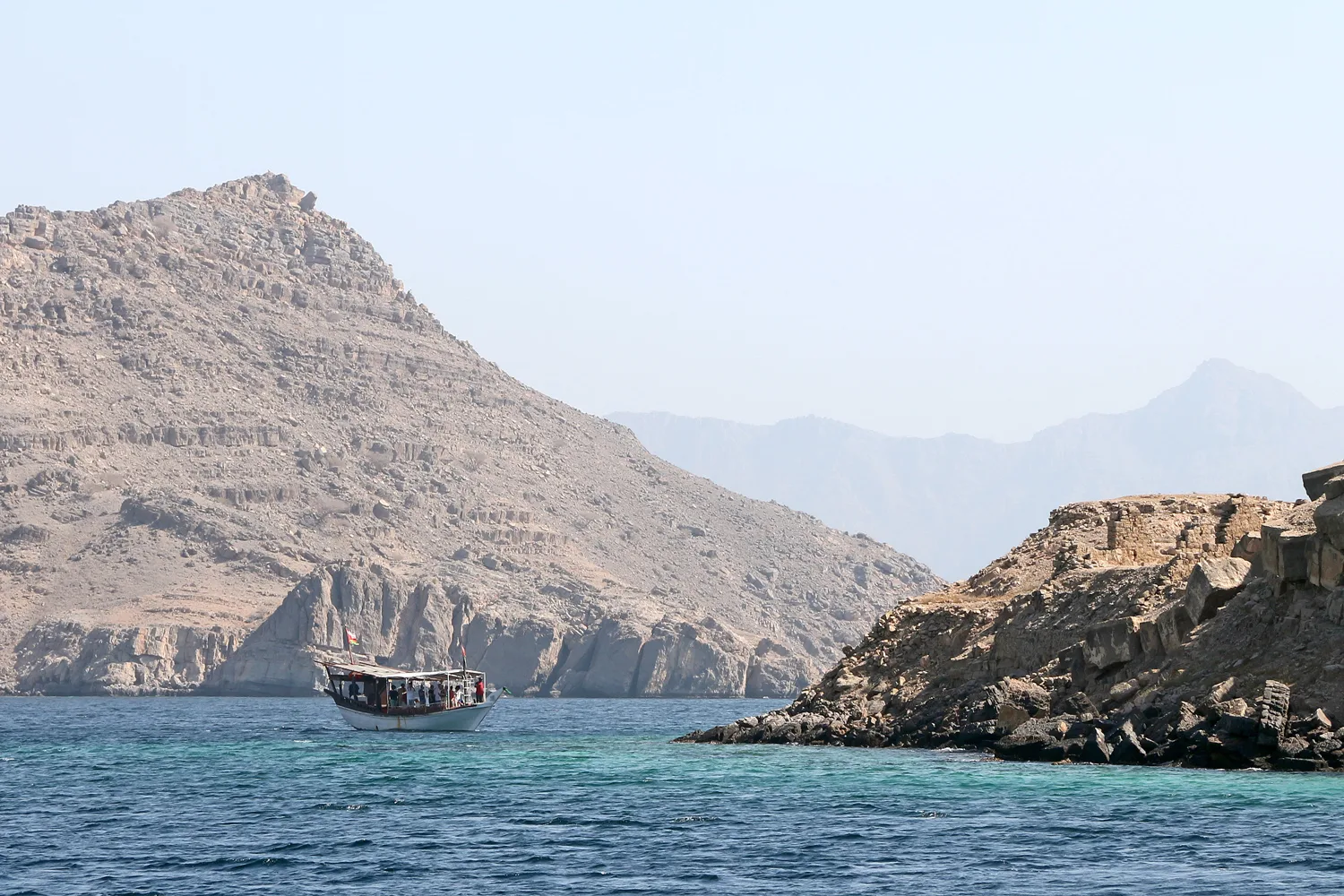 A dhow sails through a fjord near Khasab, on Oman's Musandam Peninsula at the Strait of Hormuz (file photo). UKMTO tracked Wednesday's confirmed strike on the tanker Al Dasma 11 nautical miles west of Bukha, Oman, on the same peninsula. This photo does not depict any event reported in this article.