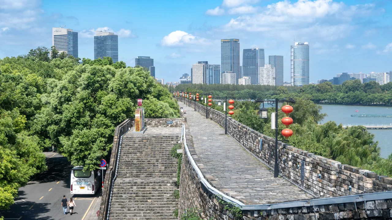 The restored city wall of Nanjing today, seen from the wall walk with the modern skyline beyond — Nanjing, renamed Tianjing by the Taipings, was their capital from 1853 until Qing forces breached its defences in July 1864. Modern photograph; it does not depict the siege or any event of the war.