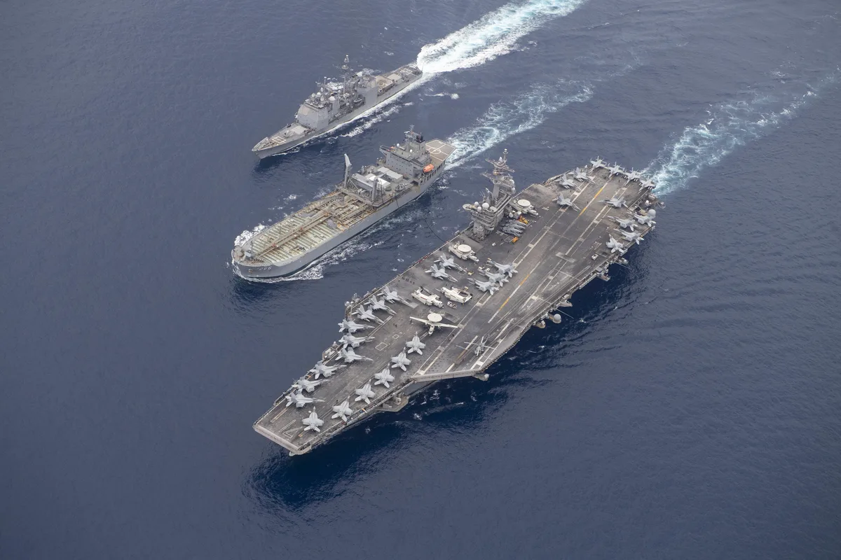 An underway replenishment: the aircraft carrier USS Theodore Roosevelt receiving fuel at sea in the Indian Ocean, March 2021. — Image: U.S. Navy / Wikimedia Commons (public domain)