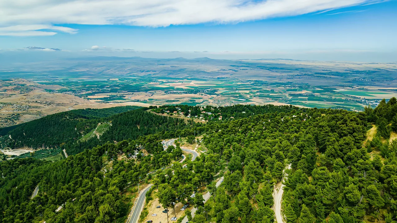Panorama over forested hills and farmland in the Golan Heights area, photographed in modern times. The Golan was captured from Syria in June 1967. This is a modern landscape photograph; it does not depict the fighting.