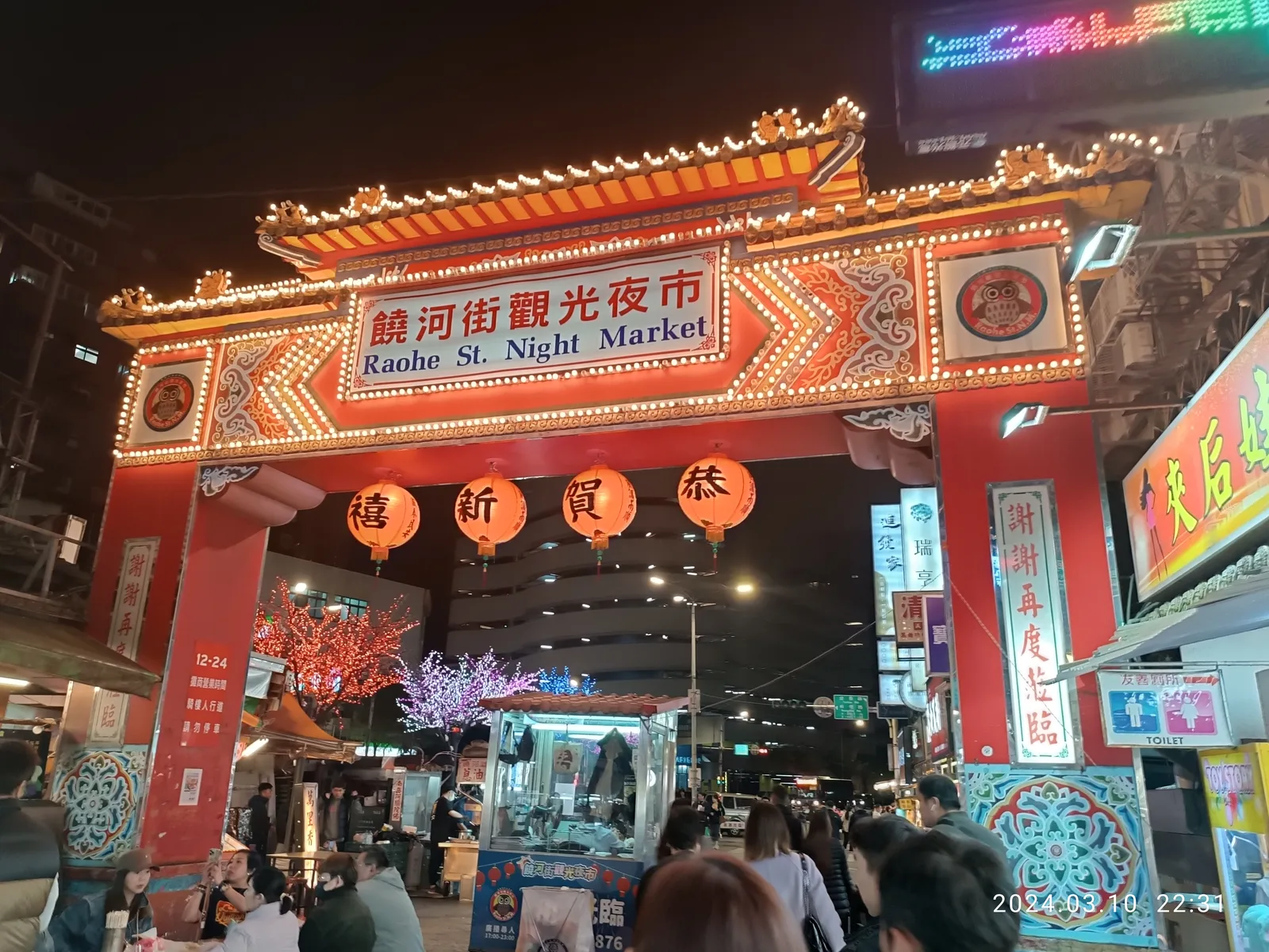 The Raohe Street Night Market entrance arch in Taipei, at night. — Photo: Ounfs Robmmy 238 / Wikimedia Commons (CC0)